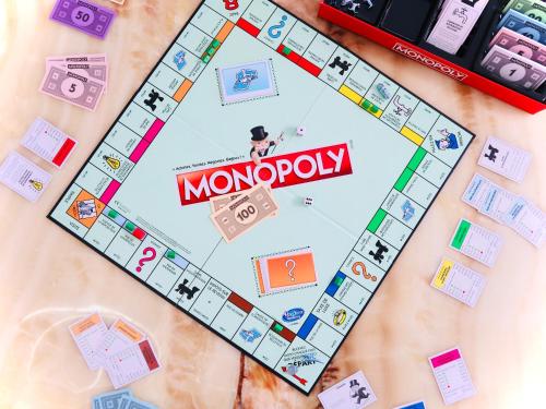 a monopoly game on a table with tokens and other items at Bourg Palette for 10 - Parking - Netflix - Wifi - Nerf in Bussy-Saint-Georges