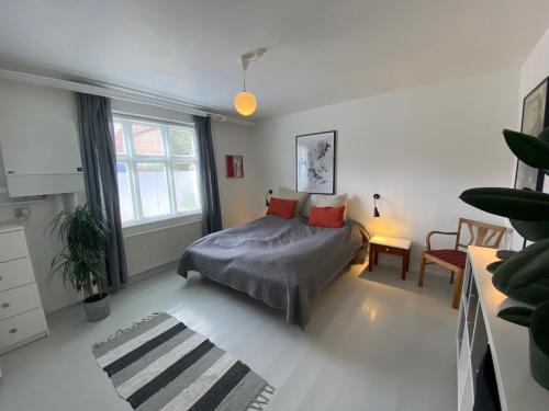 1 dormitorio con 1 cama, 1 silla y 1 ventana en City Sleep Svendborg, en Svendborg