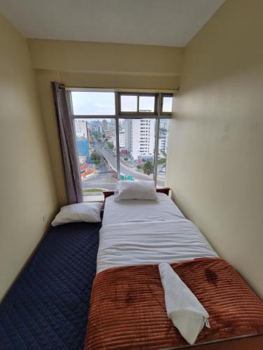 a large bed in a room with a large window at SUITE, vista hermosa de Quito in Quito