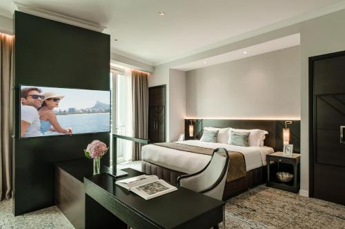 Pokój hotelowy z dużym łóżkiem i biurkiem w obiekcie Ascott Kuala Lumpur w Kuala Lumpur