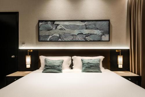 a bedroom with a large white bed with two pillows at Ascott Kuala Lumpur in Kuala Lumpur