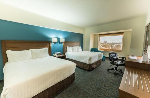 Ένα ή περισσότερα κρεβάτια σε δωμάτιο στο Holiday Inn Guadalajara Expo Plaza del Sol by IHG