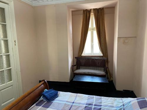 a small bedroom with a bed and a window at City center apartment in Constanţa
