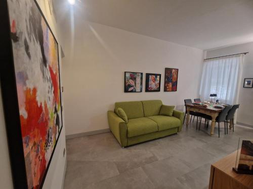 a living room with a green couch and a table at Appartamento Sotto le Torri in San Gimignano