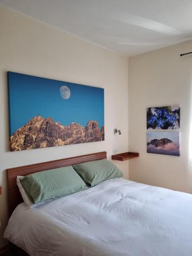 ein Schlafzimmer mit einem Bett mit einem Bild an der Wand in der Unterkunft MUN Apartment - Major Unforgettable Nights in Fuipiano Valle Imagna