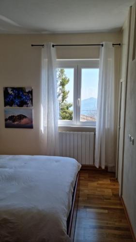 ein Schlafzimmer mit einem Bett und einem großen Fenster in der Unterkunft MUN Apartment - Major Unforgettable Nights in Fuipiano Valle Imagna