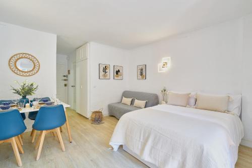 a white bedroom with a bed and a table and chairs at Gran piscina con toboganes ESTUDIO MINERVA MEDITERRANEAN SEA in Benalmádena