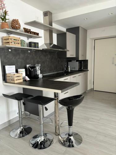 a kitchen with a counter and two bar stools at Chez Ary: Sulla strada del Lago in Clusane sul Lago