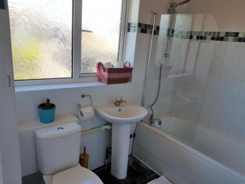 een badkamer met een toilet, een wastafel en een bad bij Eddiwick House - Huku Kwetu Dunstable -Spacious 3 Bedroom House- Sleeps 6 - Suitable & Affordable Group Accommodation - Business Travellers in Houghton Regis