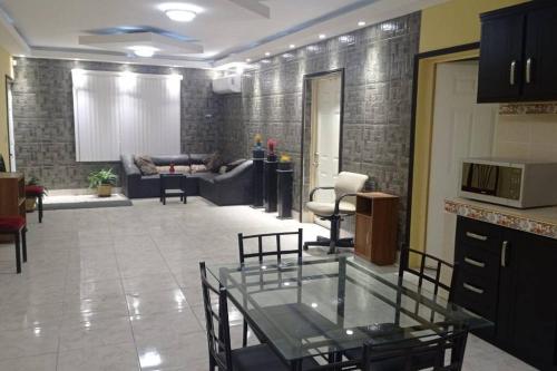 - un salon avec une table en verre et un canapé dans l'établissement Acogedor departamento en el centro de la ciudad, à Reynosa