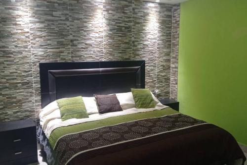 - une chambre avec un lit et un mur en briques dans l'établissement Acogedor departamento en el centro de la ciudad, à Reynosa