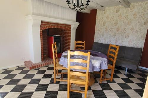une salle à manger avec une table et des chaises et une cheminée dans l'établissement Location petite maison, à Ambazac