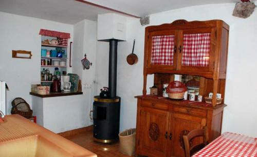 eine Küche mit einem Holzschrank und einem Tisch in der Unterkunft Le Pigeonnier Ardéchois in Saint-Julien-du-Gua