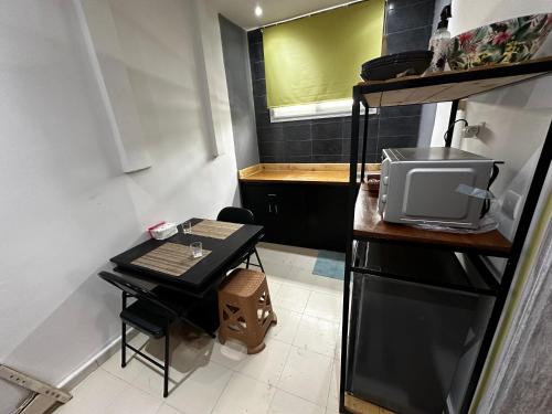 Una pequeña cocina con una mesa y un microondas. en Studio privé équipé et meublé, en Dakar