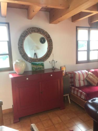 ein Wohnzimmer mit einer roten Kommode und einem Spiegel in der Unterkunft Le Pigeonnier Ardéchois in Saint-Julien-du-Gua