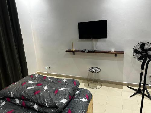Una sala de estar con un sofá y un televisor de pantalla plana. en Studio privé équipé et meublé, en Dakar