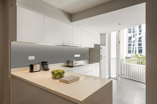 a kitchen with a counter with a bowl of fruit on it at Ascott Kuala Lumpur in Kuala Lumpur