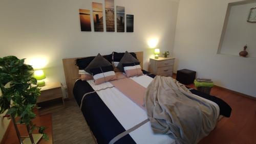 1 dormitorio con 1 cama grande con almohadas en Limonádé Apartman en Gárdony