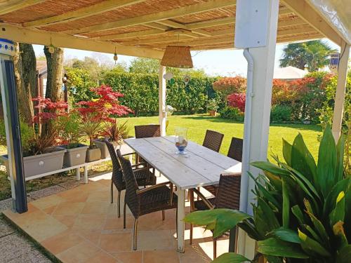 einen Holztisch und Stühle auf einer Terrasse in der Unterkunft Villa Sabry in Turriaco