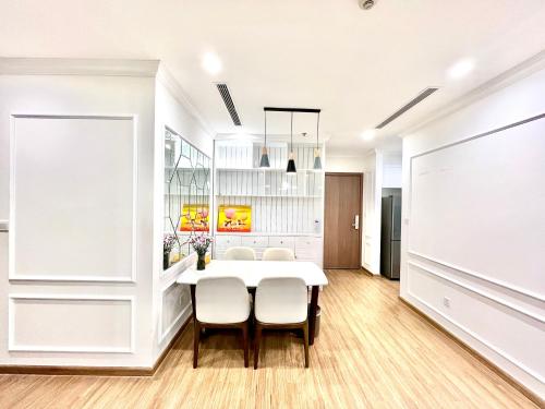Un comedor con una mesa y sillas blancas. en Nanahousing-3 Bedroom Apartment Vinhomes Skylake, en Hanói