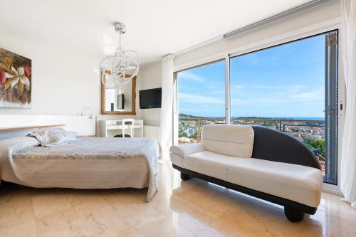 a bedroom with a bed and a chair and a window at CASA ADOSADA WELCS 137 con piscina comunitaria in Sant Feliu de Guíxols
