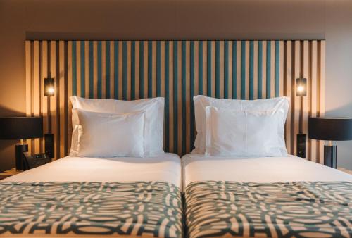 two beds sitting next to each other in a hotel room at Pico Terramar & SPA in Areia Larga