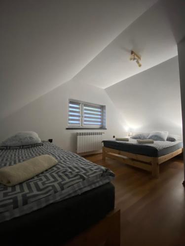 a bedroom with two beds and a window at Domek Pod Gwiazdami Bieszczady in Hużele