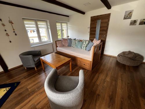 a living room with a couch and a table at Apartmány Crystalindo in Smržovka
