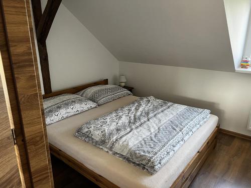 uma cama com duas almofadas num quarto em apartmán Crystalindo em Smržovka