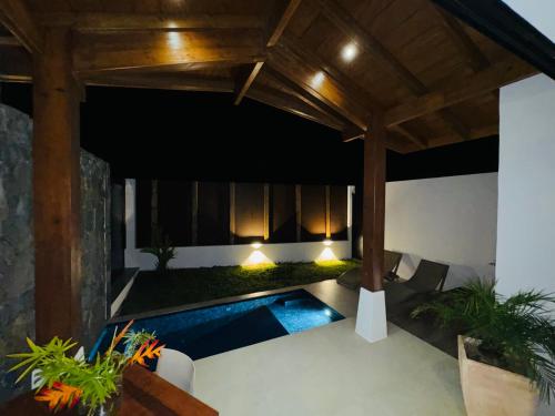 an outdoor patio with a swimming pool and a pergola at Tropical Lodges … Le Gosier in Le Gosier