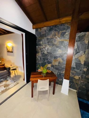 a room with a table and a stone wall at Tropical Lodges … Le Gosier in Le Gosier