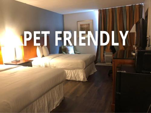 a hotel room with two beds and the words pet friendly at The Grand Hotel Spindletop in Beaumont