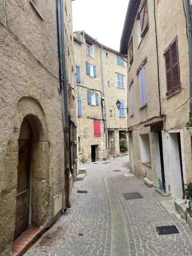 an empty alley in an old town with buildings at L’Evasion la Love Room de Fayence in Fayence