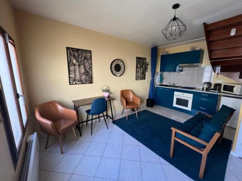 un salon avec une table et des chaises et une cuisine dans l'établissement Duplex Cosy Centre Ville, à Saint-Leu-la-Forêt