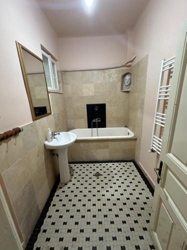 a bathroom with a sink and a bath tub and a mirror at City center apartment in Constanţa