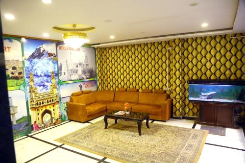 a living room with a couch and a television at Hotel MN Grand Shamshabad Airport Zone Hyderabad in Shamshabad