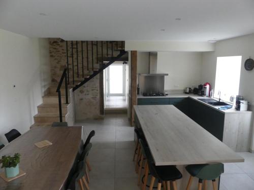 a kitchen with a long wooden table and a counter at Gîte La Maijou d'Aômés in Saint-Martin-le-Vieux