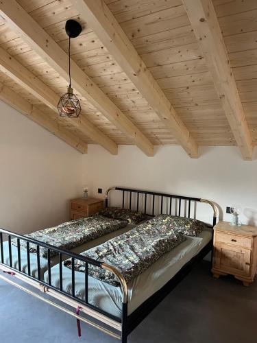 Cama grande en habitación con techo de madera en Mountain Hideout Wolfsee, en Fischbachau