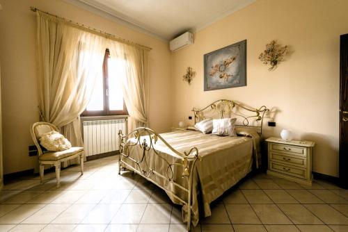 1 dormitorio con 1 cama, 1 silla y 1 ventana en Hostly-Garden House Metato-Apartment with Garden, 15min from sea en Fiocina