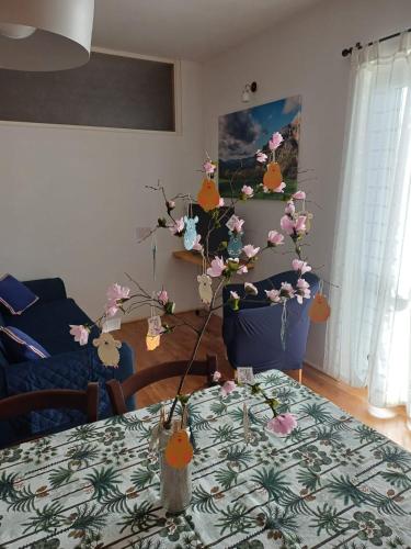 a table with a vase with flowers on it at MUN Apartment - Major Unforgettable Nights in Fuipiano Valle Imagna