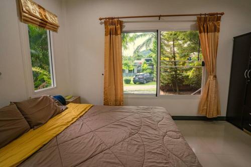 a bedroom with a large bed and a large window at Little Yellow House - AoNang in Ao Nang Beach