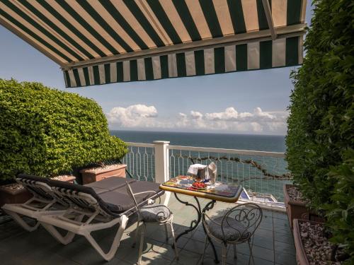 a patio with a table and chairs and the ocean at Hotel Bellevue Suite in Amalfi