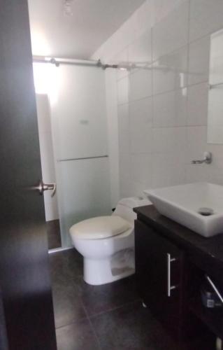 een badkamer met een wit toilet en een wastafel bij Apartamento mirador de la sierra 2 in Valledupar