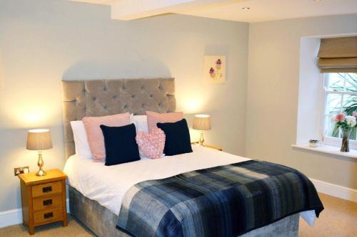 una camera da letto con un grande letto con cuscini rosa e blu di Ferienwohnung für 4 Personen ca 80 qm in Torquay, England Südküste von England a Torquay