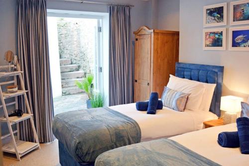 a bedroom with two beds and a sliding glass door at Ferienwohnung für 4 Personen ca 80 qm in Torquay, England Südküste von England in Torquay