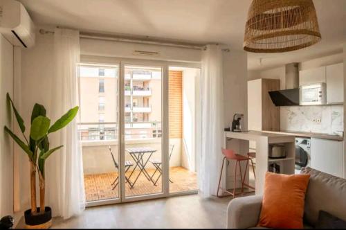 a living room with a door open to a balcony at Le Candle - Parking & Balcon - Muret - Toulouse in Muret