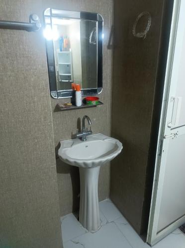 ein Badezimmer mit einem weißen Waschbecken und einem Spiegel in der Unterkunft CITY Beautiful Travellers Room in Panchkula