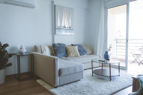 uma sala de estar com um sofá e uma mesa em Blue Touch Pervolia Paradise Near The Beach em Lárnaca
