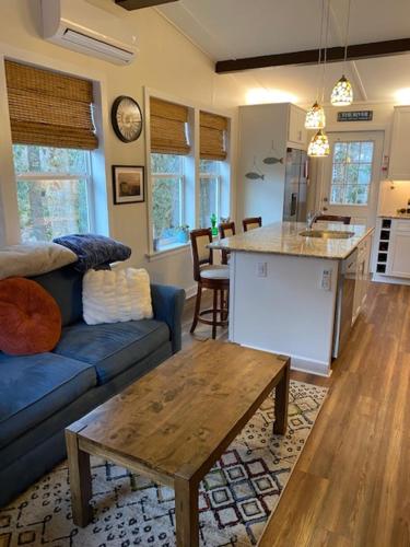 a living room with a blue couch and a table at River Run Cottage Modern 2BR Waterfront Retreat in Linville Land Harbor in Newland
