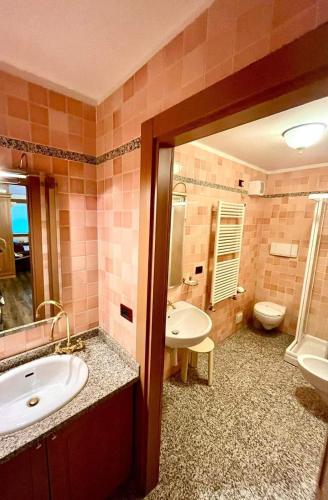 y baño con lavabo, bañera y aseo. en Orsa Maggiore, en Madonna di Campiglio